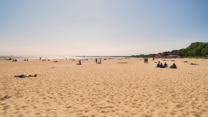 17 Wide, sandy beach populated by several people sunbathing and relaxing